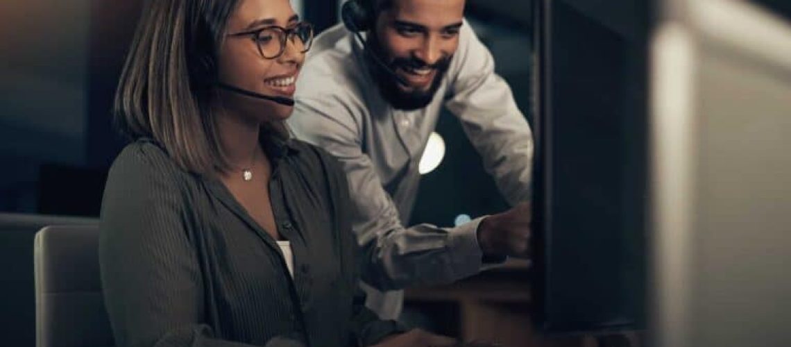 shot-of-two-call-centre-agents-working-together-in-an-office-at-night-768x513